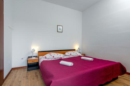 a bedroom with a large pink bed with two pillows at Family friendly apartments with a swimming pool Valbandon, Fazana - 2201 in Štinjan