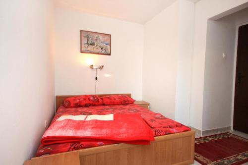 a bedroom with a bed with a red comforter at Apartments with a parking space Peroj, Fazana - 2234 in Peroj