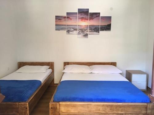 2 Betten in einem Zimmer mit 2 Gemälden an der Wand in der Unterkunft Family friendly seaside apartments Cove Torac, Hvar - 2071 in Gdinj