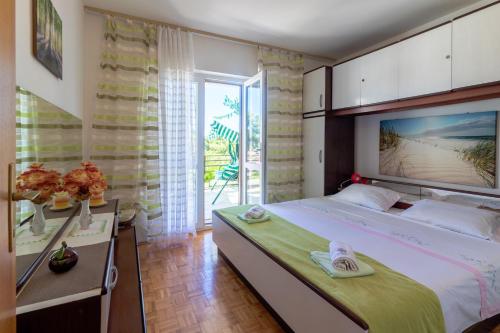 ein Schlafzimmer mit großem Bett und Balkon in der Unterkunft Apartments by the sea Jelsa, Hvar - 4017 in Jelsa