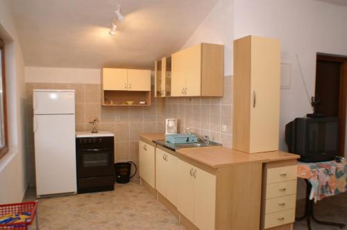 cocina con armarios blancos y nevera blanca en Apartments with a parking space Mudri Dolac, Hvar - 4043, en Vrbanj