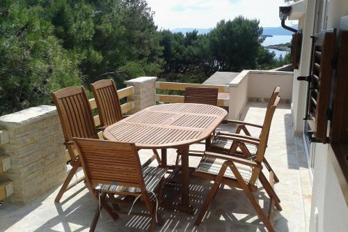 a wooden table and chairs on a patio at Apartments by the sea Mudri Dolac, Hvar - 4026 in Vrboska