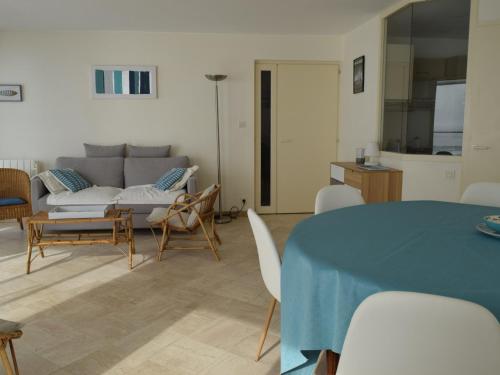 un salon avec un canapé, une table et des chaises dans l'établissement Appartement 2 étoiles avec balcon-terrasse, 1 chambre, parking, près de la mer - FR-1-197-491, à Les Sables-dʼOlonne