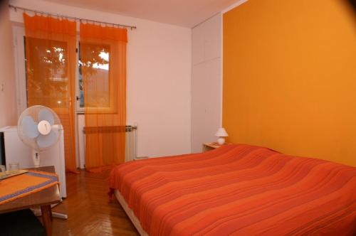1 dormitorio con cama de color naranja y ventana en Rooms by the sea Jelsa, Hvar - 4041, en Jelsa