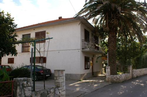 a white house with a palm tree in front of it at Double Room Jelsa 4041d in Jelsa