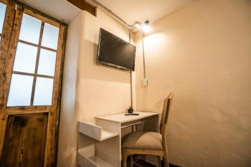 a room with a desk and a tv on the wall at The Luun Hostel in Bogotá