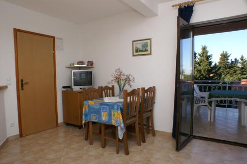 a dining room with a table and chairs and a television at Apartments with a parking space Stari Grad, Hvar - 4014 in Stari Grad