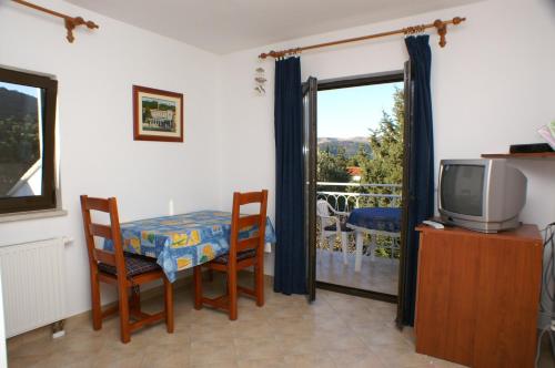 a room with a table and a tv and a balcony at Apartments with a parking space Stari Grad, Hvar - 4014 in Stari Grad