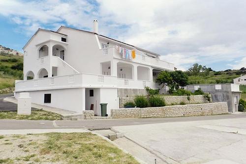 una casa blanca con una escalera en la parte superior en Apartments with a parking space Metajna, Pag - 4127, en Zubovići