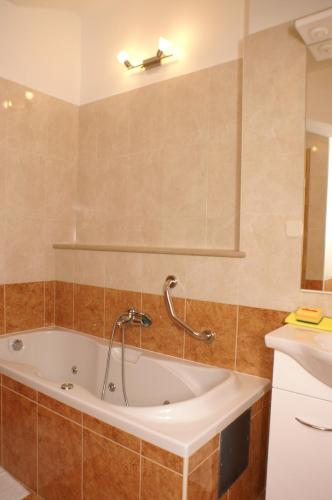 a bathroom with a tub and a sink at Apartments by the sea Supetar, Brac - 4274 in Supetar