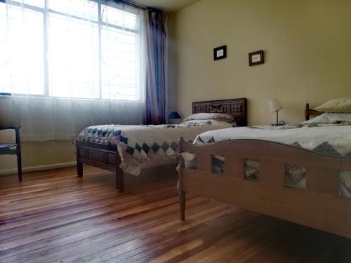 1 dormitorio con 2 camas y ventana grande en Fully Equipped Appartment in Quito Centre, en Quito