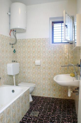 a bathroom with a sink and a tub and a toilet at Family friendly seaside apartments Vlasici, Pag - 4131 in Vlašići