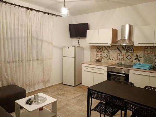 eine Küche mit einem Kühlschrank und einem Tisch mit Stühlen in der Unterkunft Apartment Metajna 4150b in Metajna