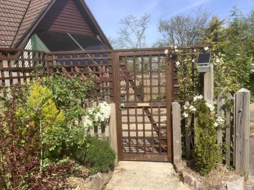 a wooden fence with a gate and a garden at The Forge in Winscombe