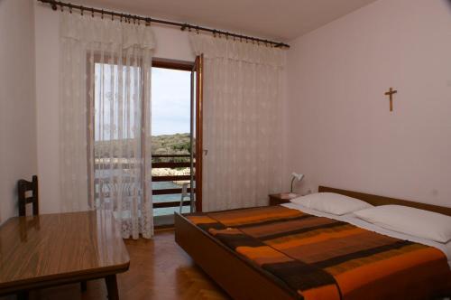 a bedroom with a bed and a large window at Rooms by the sea Cove Mulobedanj, Pag - 4061 in Lun