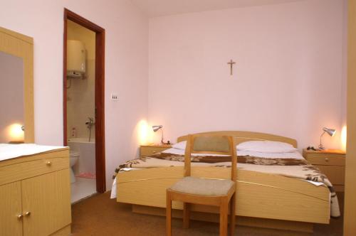 a bedroom with a bed with a cross on the wall at Double Room Mulobedanj 4061c in Lun