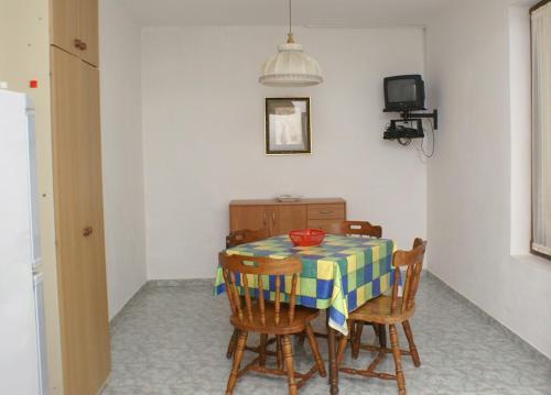 a dining room with a table and four chairs at Apartment Novalja 4114a in Novalja
