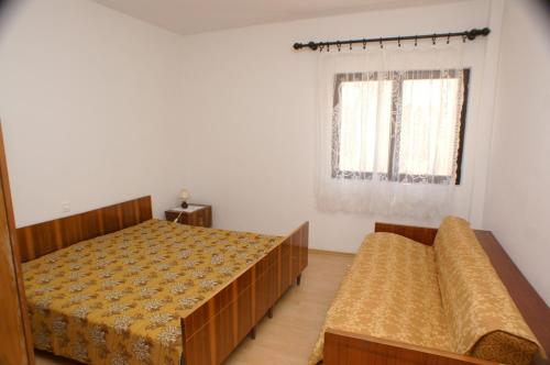 a bedroom with two beds and a window at Apartments and rooms by the sea Zubovici, Pag - 4065 in Zubovići
