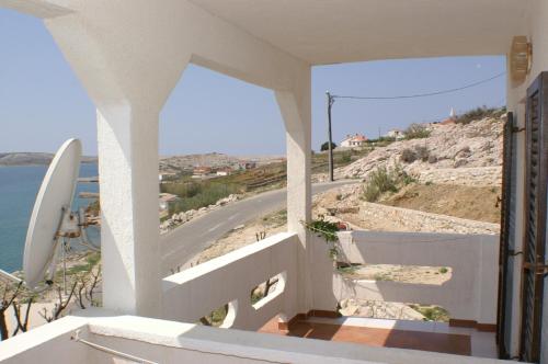 a balcony with a view of a beach and a road at Apartments and rooms by the sea Zubovici, Pag - 4065 in Zubovići