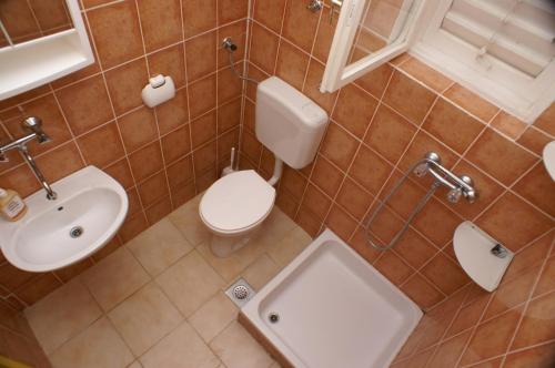 ein Badezimmer mit einem weißen WC und einem Waschbecken in der Unterkunft Apartment Grebastica 4207b in Bašelovići