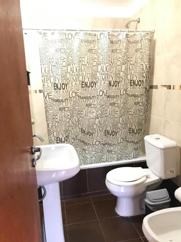 a bathroom with a toilet and a shower curtain at Departamento Pájaro Carpintero in Ushuaia