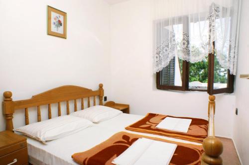 Schlafzimmer mit einem Bett und einem Fenster in der Unterkunft Apartments with a parking space Potocnica, Pag - 4096 in Stara Novalja