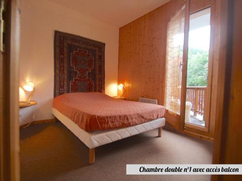 a bedroom with a bed and a large window at Chalet Valloire, 4 pièces, 8 personnes - FR-1-263-517 in Valloire