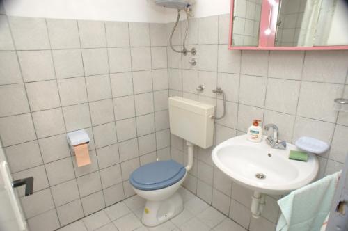 bagno con servizi igienici blu e lavandino di Apartments with parking space Vodice - 4192 a Vodice