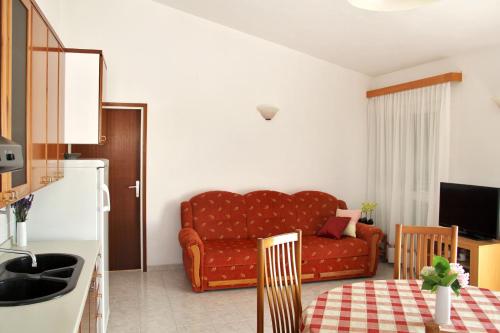 a living room with a red couch and a table at Apartments by the sea Razanj, Rogoznica - 4253 in Ražanj