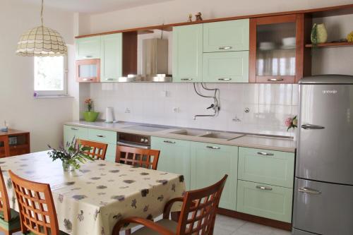 a kitchen with a table and a refrigerator at Apartments by the sea Razanj, Rogoznica - 4253 in Ražanj