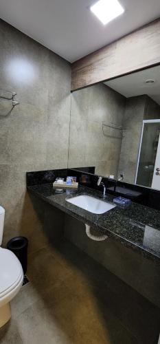 ein Bad mit einem Waschbecken und einem WC in der Unterkunft Flat Maravilhoso na praia - Ilusion Hotel in Natal