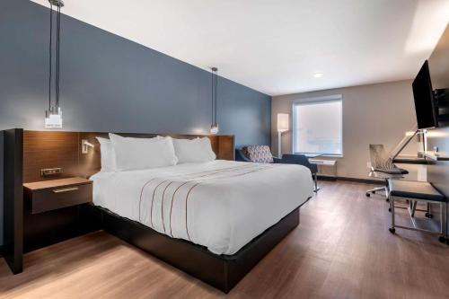 ein Hotelzimmer mit einem großen Bett und einem Schreibtisch in der Unterkunft Vīb Hotel by Best Western Denver RiNo in Denver