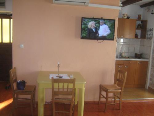 a kitchen with a yellow table and a tv on the wall at Apartments by the sea Sepurine, Prvic - 4237 in Prvić Šepurine