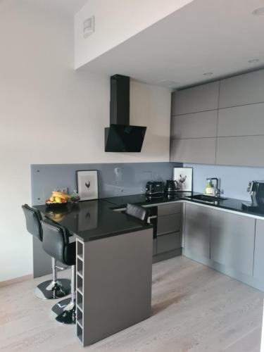 cocina con encimera negra y armarios blancos en The Familytree- Martensi, en Pärnu
