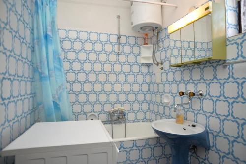 La salle de bains bleue et blanche est pourvue d'un lavabo et d'un miroir. dans l'établissement Apartments with a parking space Vodice - 4180, à Vodice