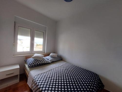 ein Schlafzimmer mit einem Bett und zwei Fenstern in der Unterkunft Apartments by the sea Rastici, Ciovo - 4293 in Trogir