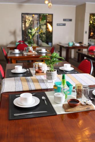 a wooden table with plates and dishes on it at Tikay Suite Hotel in Copiapó