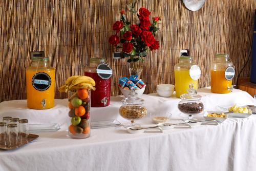 a table with bottles of orange juice and fruit on it at Tikay Suite Hotel in Copiapó