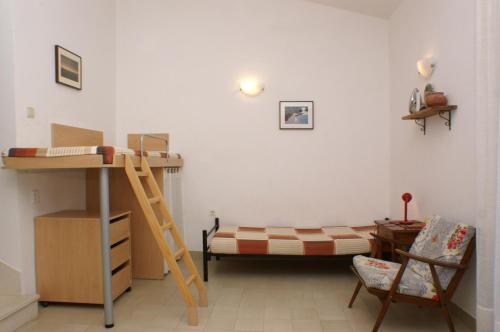 a bedroom with a bunk bed and a ladder at Apartments by the sea Nemira, Omis - 4277 in Tice