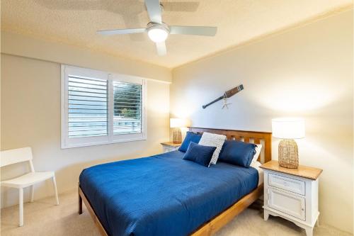a bedroom with a blue bed and a window at Shoal Towers, 6 -11 Shoal Bay Rd - Air Conditiong - Wifi - Stunning water views & perfect location in Shoal Bay