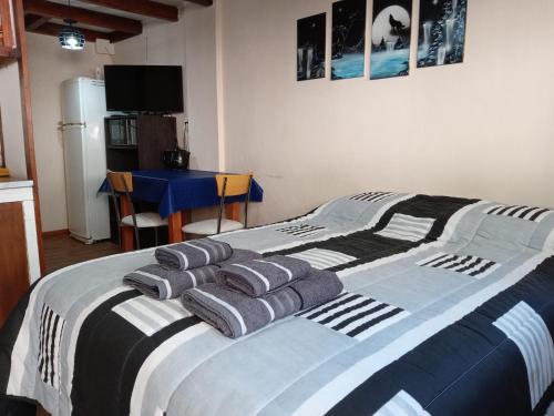 um quarto com uma cama com três almofadas em EL MONO DE LU em San Carlos de Bariloche