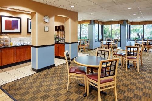 a dining room with tables and chairs and a kitchen at La Quinta by Wyndham Thousand Oaks-Newbury Park in Thousand Oaks