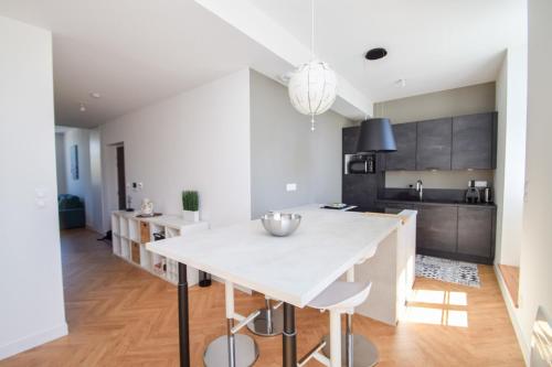 - une cuisine avec une grande table blanche dans une pièce dans l'établissement Appt 3 pièces haut de gamme dans la 