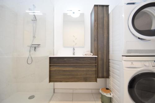 a bathroom with a shower and a sink and a washing machine at Appt 3 pièces haut de gamme dans la " Villa Hortense" à 200 m plage in Dinard
