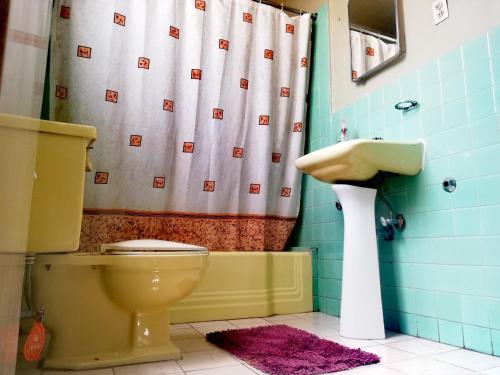 y baño con aseo y lavamanos. en Fully Equipped Appartment in Quito Centre, en Quito