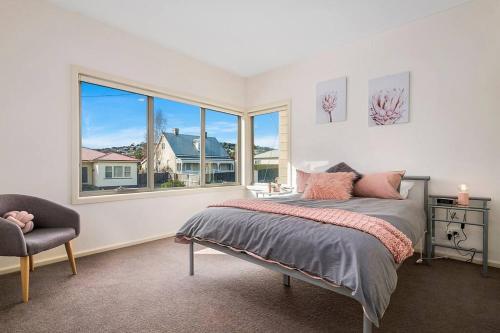 - une chambre avec un lit et une grande fenêtre dans l'établissement Bellerive Quay-views walk to wharf & restaurants, à Bellerive