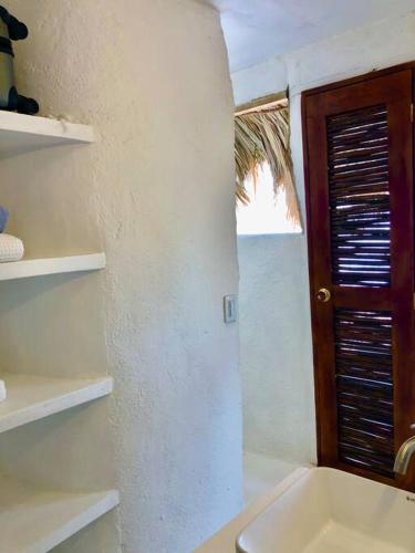 a bathroom with a sink and a wooden door at Acuarela del Mar in Dibulla