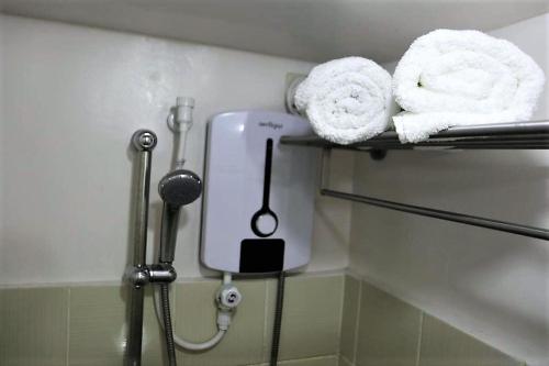 a bathroom with towels and a hair dryer on a shelf at Ohana at Tagaytay Prime in Tagaytay