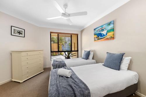 1 Schlafzimmer mit 2 Betten und einem Fenster in der Unterkunft Corona St Secluded Sunshine Beach Duplex with Private Pool in Sunshine Beach