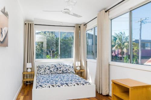 a bedroom with a bed and large windows at Bayhaven in Iluka
